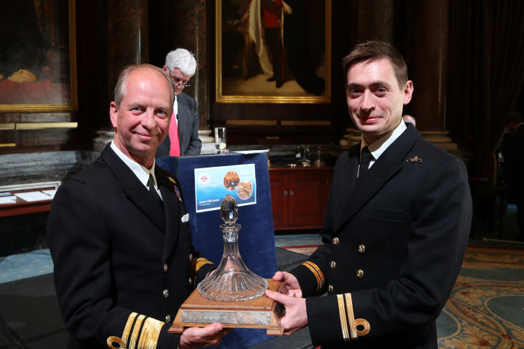 Vice Admiral Jerry Kyd CBE presents Lt Elliott Millward RN on behalf of 45 Commando with the Desmond Wettern Fleet Award 2021 at the Maritime Media Awards 2020 and 2021 as the Maritime Foundation returned to Londons Drapers Hall on Friday, 27 May 2022 at a reception and lunch attended by a diverse representation of the maritime community and the past two years of the book, film, digital media, and journalism award winners.